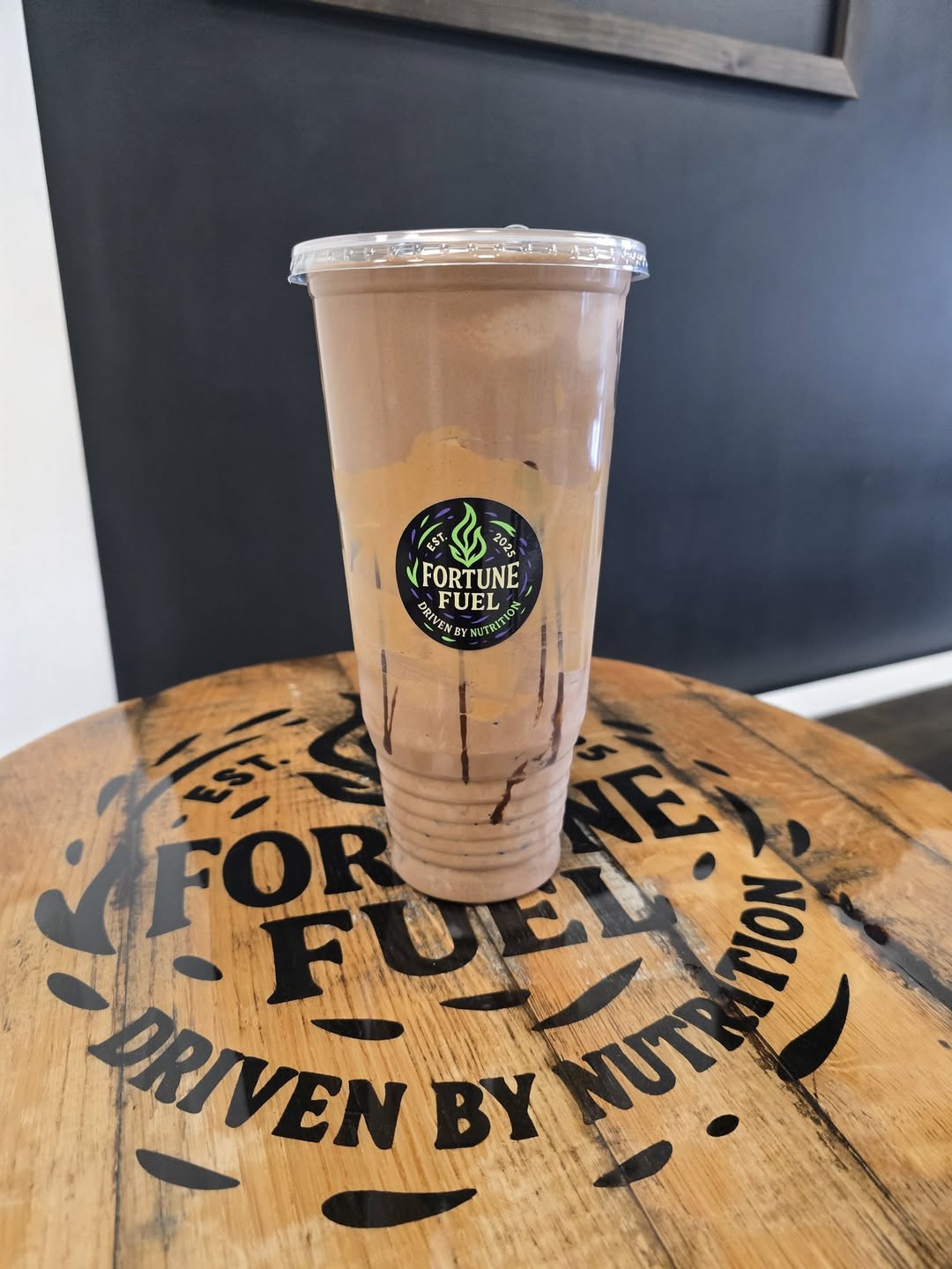 A Fortune Fuel shake on a branded barrel table reading Driven by Nutrition