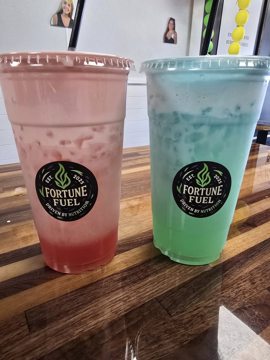 A layered pink tea and a layered teal tea side by side, each with a Fortune Fuel sticker